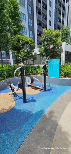 a playground with playground equipment on a blue carpet at Mimpi Muji Gamuda Cove in Pulau Kempas