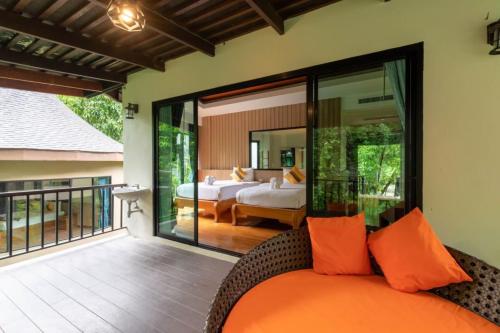 a bedroom with a bed and a balcony at Rock and Tree House Resort in Khao Sok
