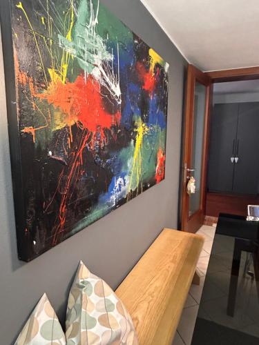 a painting hanging on a wall next to a couch at Appartamento da Bunny & Brownie in Noventa di Piave