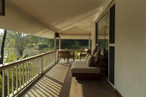 a porch with a couch and a table on it at Tree of Life Ramvilas, Bandhavgarh in Tāla