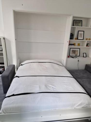 a white bed in a room with a white wall at Appartement City Center in Vienna