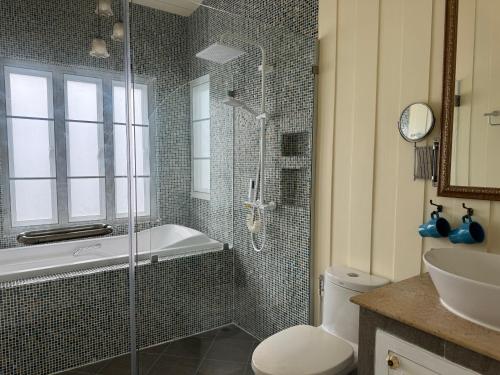 a bathroom with a shower and a toilet and a sink at Pailin Pool Villa,HuaHin in Hua Hin