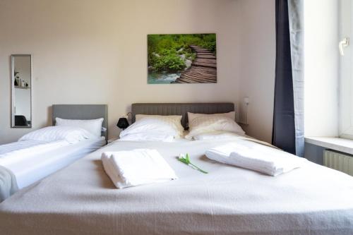 two beds with white pillows sitting next to each other at COY Apartments Leoben - Stay Comfortable & Work Smart in Leoben