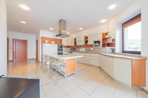 a large kitchen with white appliances and a large window at Raca Retreat in Rača