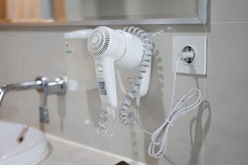 a hair dryer on a wall in a bathroom at Sahid Bandara Soekarno Hatta in Tangerang