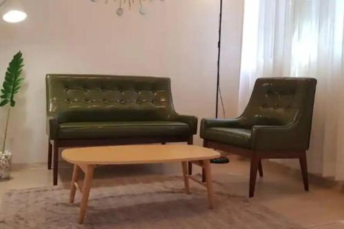 two green leather chairs and a coffee table in a room at S1 Private Kintex Daehwadong in Goyang