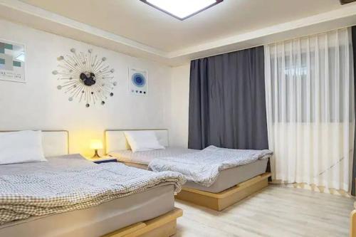 two beds in a bedroom with a window at S1 Private Kintex Daehwadong in Goyang