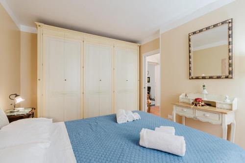 Un dormitorio con una cama azul y un espejo. en Appartamento Marsalasuitesawfarm, en Marsala