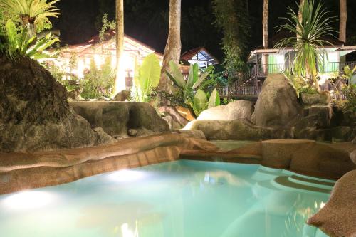a swimming pool in a garden at night at Rock and Tree House Resort in Khao Sok