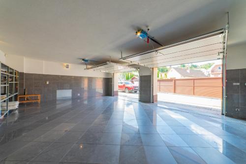 an empty garage with a ceiling fan and a tiled floor at Raca Retreat in Rača