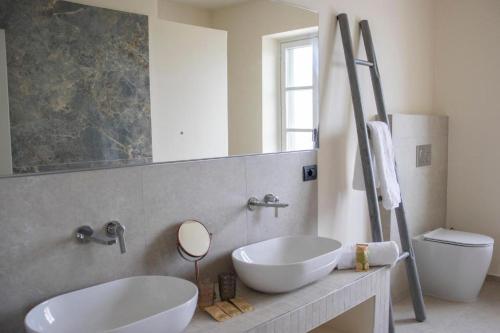 a bathroom with two white sinks and a mirror at Splendid Villa Magna with Pool and Park - Langhe Hills in Govone