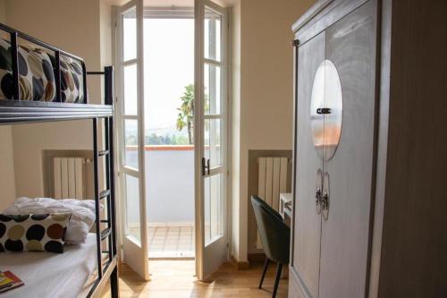 a bedroom with a bunk bed and a door with a window at Splendid Villa Magna with Pool and Park - Langhe Hills in Govone