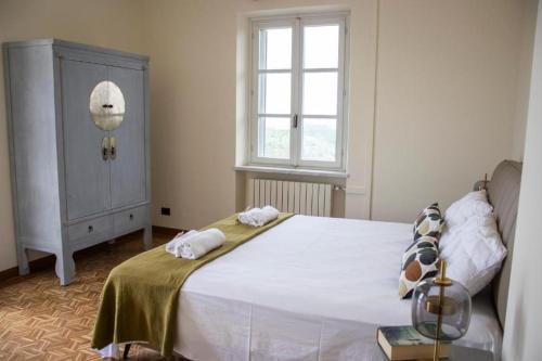 a bedroom with a bed with towels on it at Splendid Villa Magna with Pool and Park - Langhe Hills in Govone