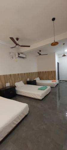 a room with three beds in a room at HYTON GRAND in Urapakkam