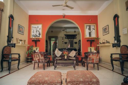 a living room with red walls and chairs at Baruah Bhavan Homestay in Guwahati