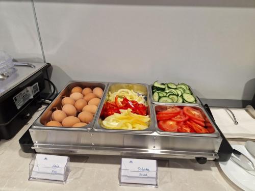 a tray of vegetables and eggs on a counter at Navigator in Palić