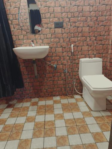 a bathroom with a white toilet and a sink at Carolina Deluxe Apartments and Wi-Fi RoomS in Colva