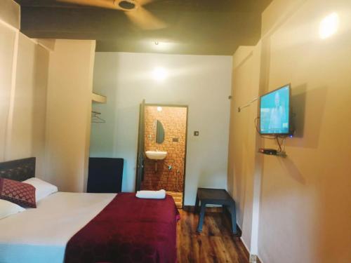a hotel room with a bed and a television at Carolina Deluxe Apartments and Wi-Fi RoomS in Colva