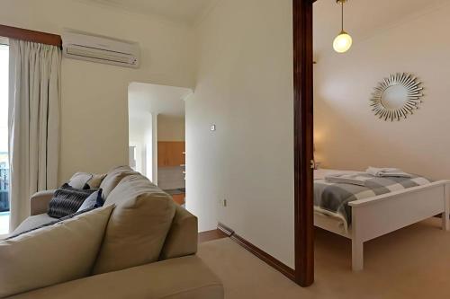 ein Wohnzimmer mit einer Couch und einem Spiegel in der Unterkunft Mr Watson's Cottage near the Battery Point Jetty in Hobart