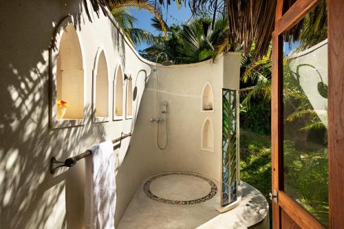 a bathroom with a shower and a glass door at Qambani Luxury Resort in Michamvi