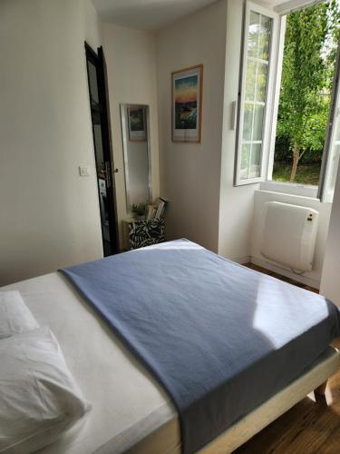 - une chambre avec un lit doté d'une couverture bleue dans l'établissement Agréable appartement à CAMBO LES BAINS, à Cambo-les-Bains