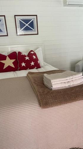 a bedroom with a bed with red and white pillows at Skärgårdsidyll i Stavsnäs Idyllic Archipelago Retreat in Stavsnäs in Stockholm