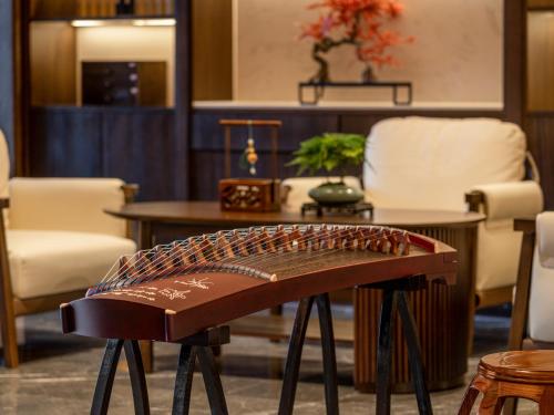 a bench in a room with a table and chairs at Beijing Renjoy Hotel in Beijing