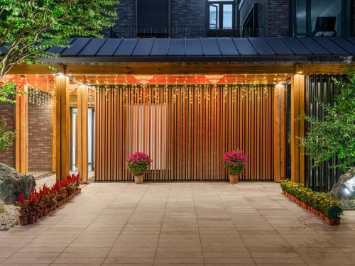 a gate with lights and flowers in a courtyard at Beijing Renjoy Hotel in Beijing