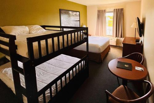 a hotel room with two bunk beds and a table at Super 8 by Wyndham Amherst NS in Amherst