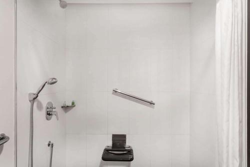 a white bathroom with a shower and a toilet at Wyndham Guayaquil, Puerto Santa Ana in Guayaquil