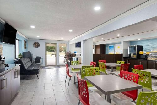 a restaurant with tables and chairs and a kitchen at Days Inn by Wyndham Miami in Miami