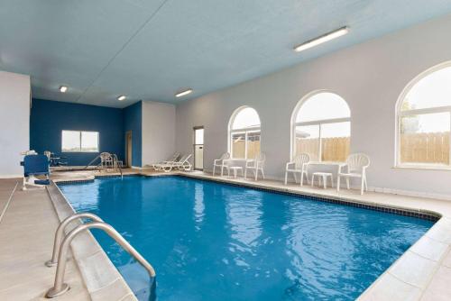 a swimming pool with chairs and tables in a building at Days Inn by Wyndham Miami in Miami