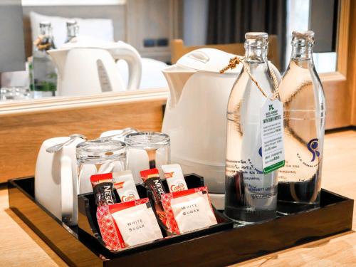 a tray with two bottles and glasses on a counter at Phuket Orchid Resort and Spa in Karon Beach