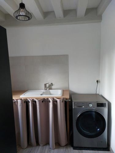 une cuisine avec une machine à laver et un évier dans l'établissement Saint André- Lovely house, à Saint-André-dʼAllas