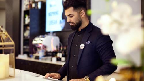 a man standing at a counter in a bar at Holiday Inn - the niu, Air Frankfurt Messe by IHG in Frankfurt/Main