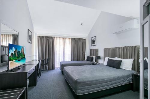 a hotel room with a bed and a television at Comfort Inn & Apartments Northgate Airport in Brisbane