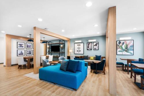 a living room with a blue couch and a dining room at Everhome Suites Lexington - Horse Park in Lexington