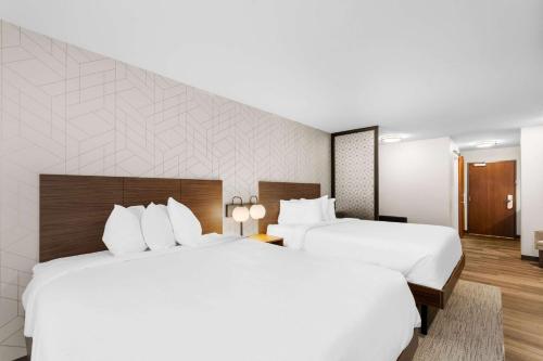 two beds in a hotel room with white pillows at Everhome Suites Lexington - Horse Park in Lexington
