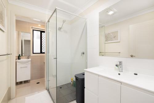 a white bathroom with a shower and a sink at Smart Suites Self Check-in Apartments - Sunnybank Station in Brisbane