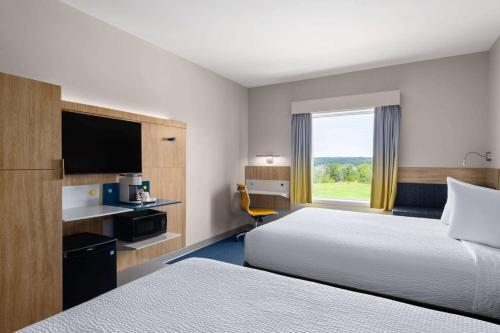 a hotel room with two beds and a window at Microtel Inn & Suites by Wyndham Lachute in Lachute