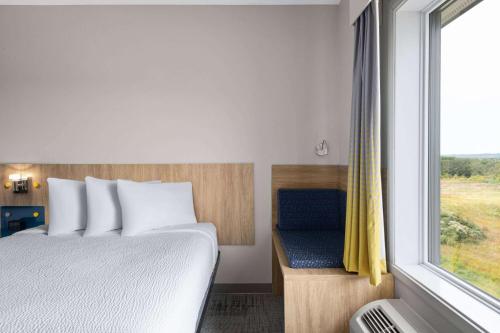 a bedroom with a bed and a window at Microtel Inn & Suites by Wyndham Lachute in Lachute