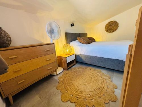 - une chambre avec un lit, une commode et un tapis dans l'établissement La Villa Sylody restaurant, 3 piscines et location de vélo sur place, à Lecci