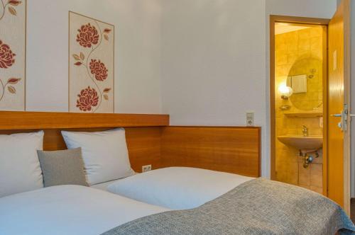 a bedroom with a bed and a sink in it at Sautter Hotel Stuttgart City in Stuttgart