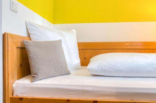 a bed with white sheets and a pillow on it at Sautter Hotel Stuttgart City in Stuttgart