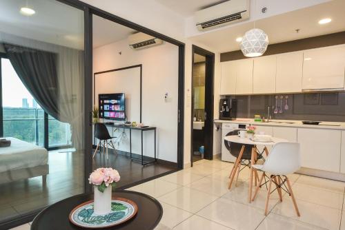 a kitchen and living room with a table and chairs at Almas Suite by Nest Home【Puteri Harbour & LEGOLAND】 in Nusajaya