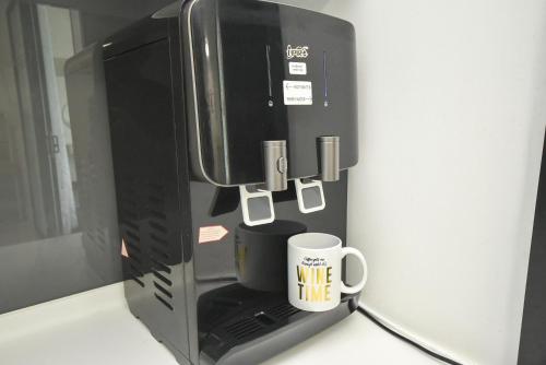 a coffee cup is plugged into a microwave oven at Almas Suite by Nest Home【Puteri Harbour & LEGOLAND】 in Nusajaya