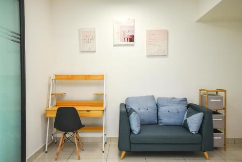 a living room with a blue chair and a desk at Almas Suite by Nest Home【Puteri Harbour & LEGOLAND】 in Nusajaya