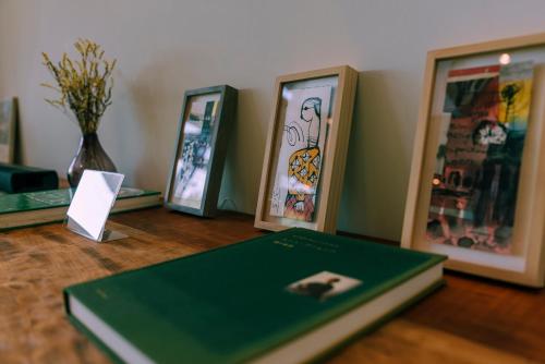 a table with three framed pictures and a book at 女性のための森サウナ 一棟貸し宿 SORA 宙 Forest sauna villa SORA in Komoro