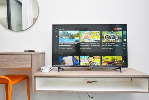 a tv screen on a desk with a table at Almas Suite by Nest Home【Puteri Harbour & LEGOLAND】 in Nusajaya