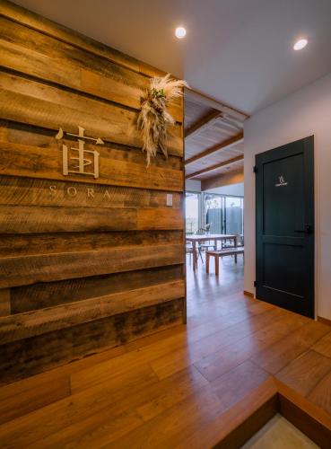 a large wooden wall in a room with a door at 女性のための森サウナ 一棟貸し宿 SORA 宙 Forest sauna villa SORA in Komoro
